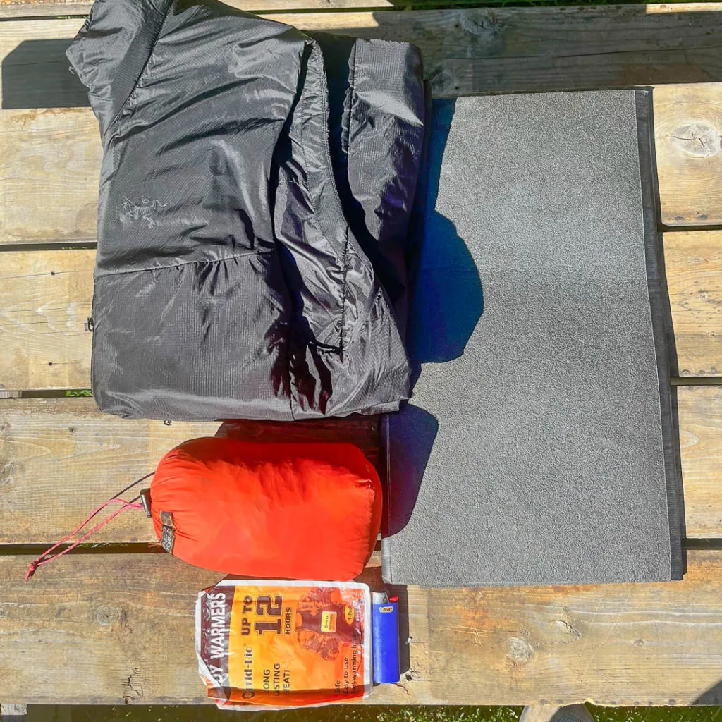 Basic patient packaging: puffy vest, rescue sled/tarp, foam pad, and handwarmers.