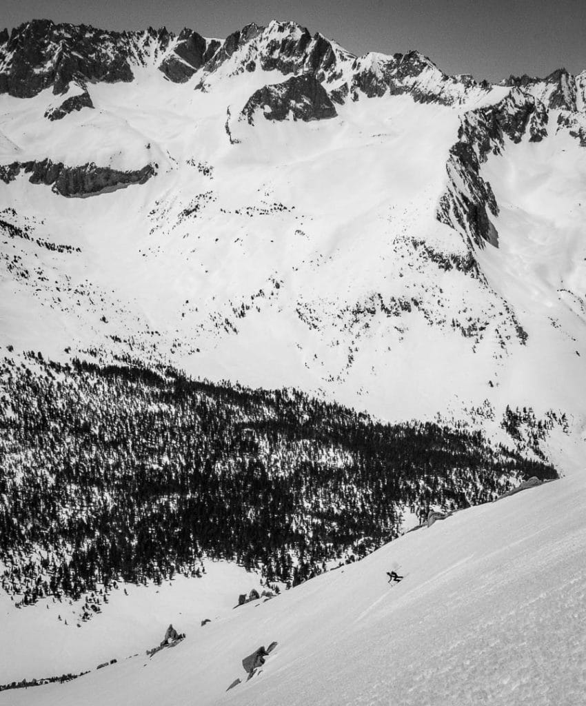 Lane skis down to valley bottom, moving deeper into the High Sierra on a day around University Peak.