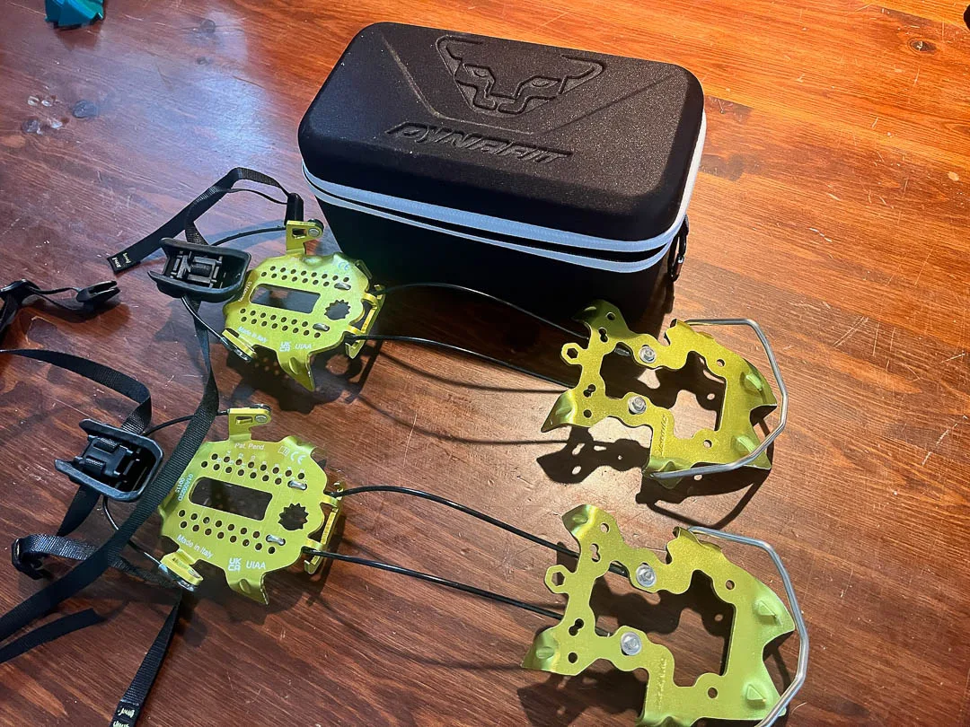 Dynafit DNA crampons: 6 point aluminum front section, coated steel cable linkage, and aluminum rear section.