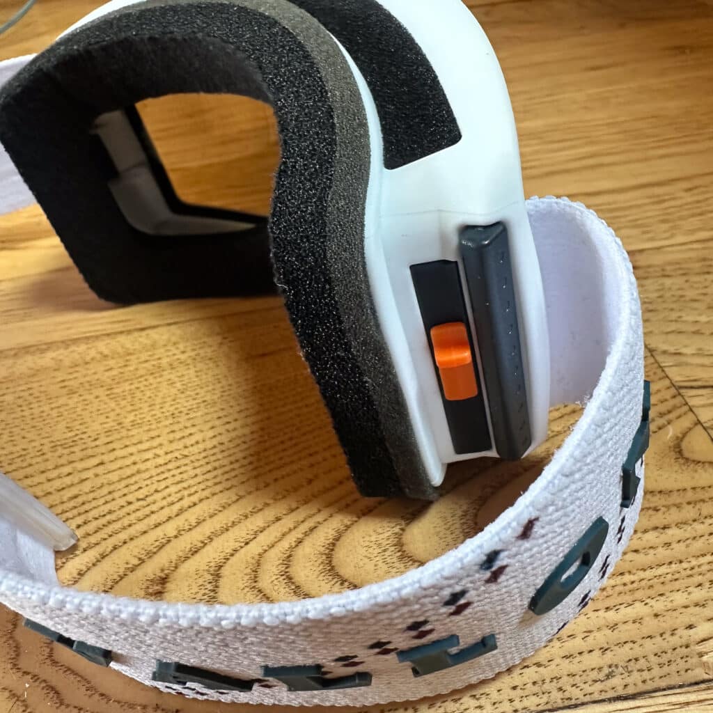 A close-up of the orange slider, which is used to remove the lens.