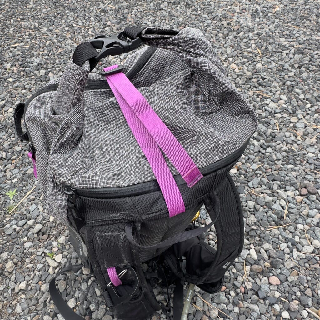 The roll top is closed up. The purple strap can act as a rope carry or a place to stash a puffy on days with cold temps and lots of transitions.