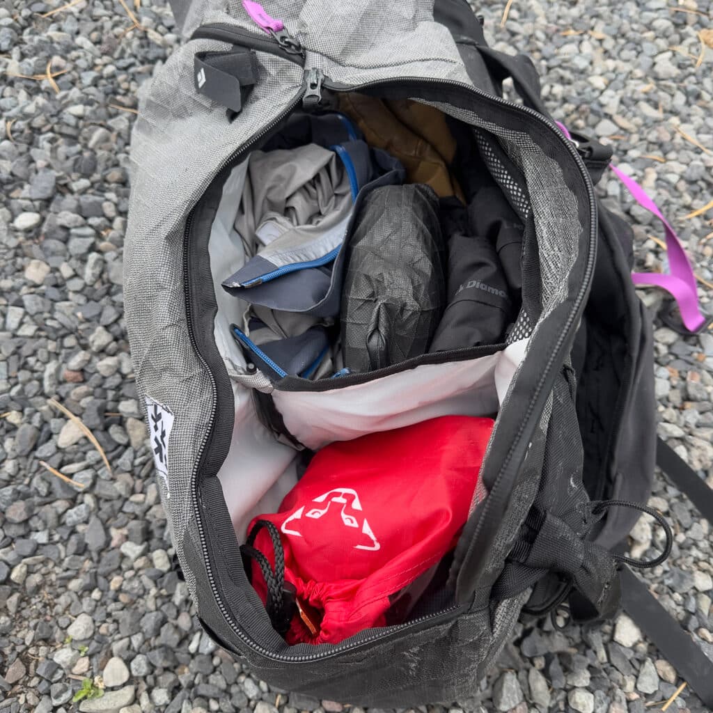 A view of the side zip opened up. The lower space is great for storing skins, crampons, and ski crampons. The upper space is ideal for a hardshell, water, extra gloves, a puffy, and other odds and ends.