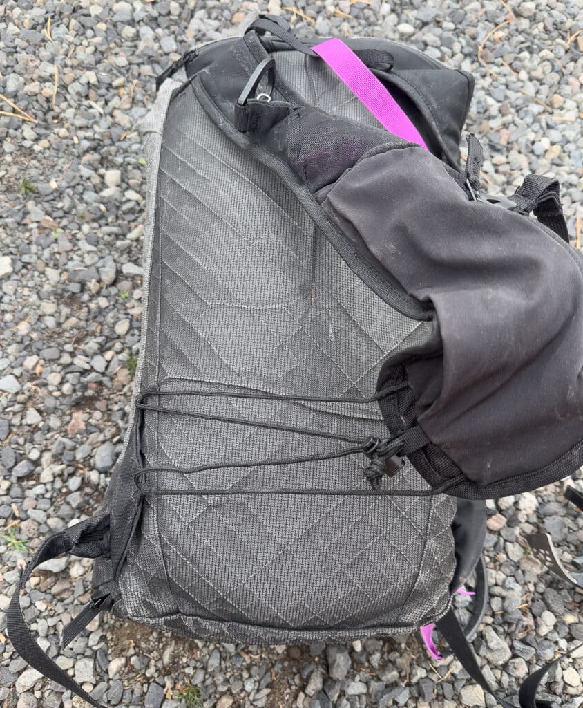 This is a ski-vest style pack. The shoulder straps are adjusted with a simple cord system shown here.