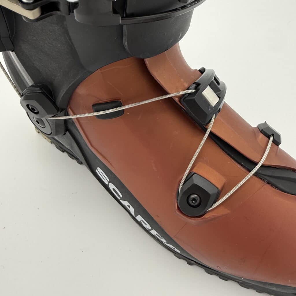 Note the small rubber tab near the center; ensure the cable runs over it when tightening.